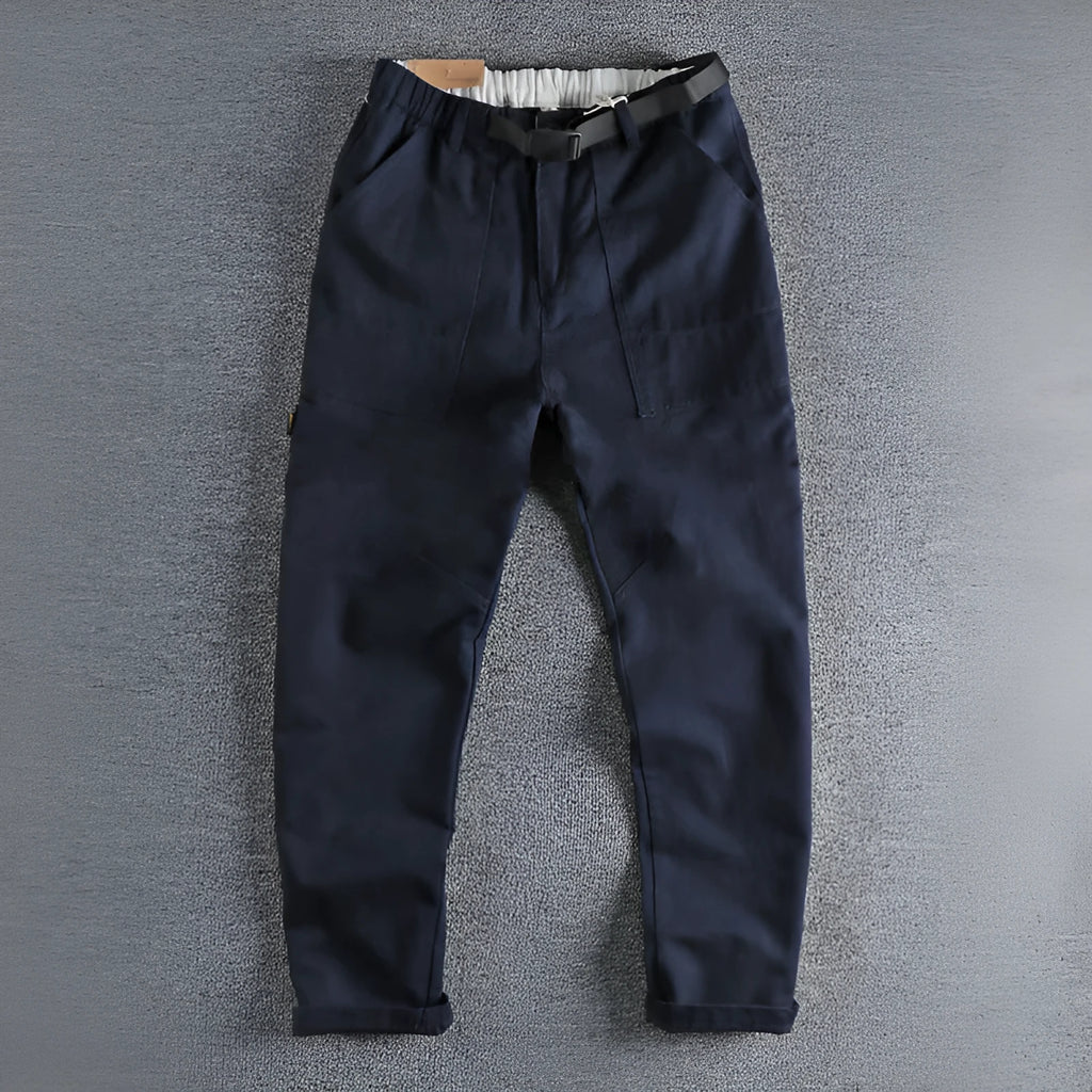 Men's dark blue cotton work trousers with N I buckle belt showing three-dimensional cutting and zip fly fastening
