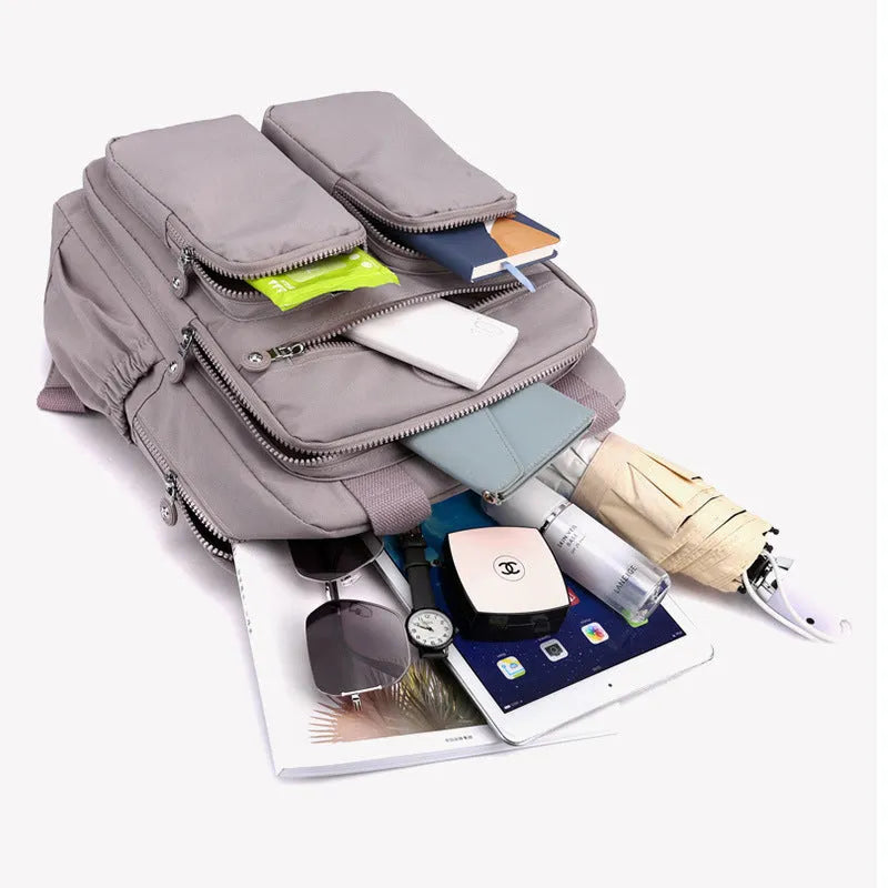 Women's waterproof nylon travel backpack showing internal organisation compartments and colour options