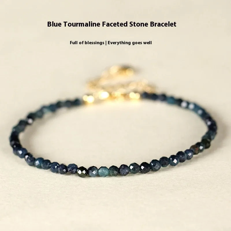 Blue tourmaline bracelet with 3mm beads and spacer beads on a wrist.
