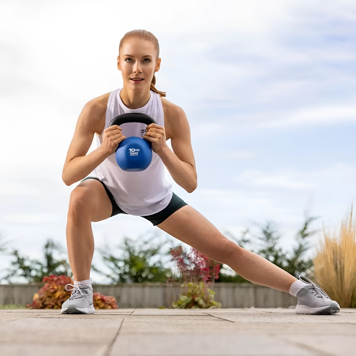 Blue cast iron teapot-shaped kettlebell with a handle, showing its 10kg weight for home gym use.