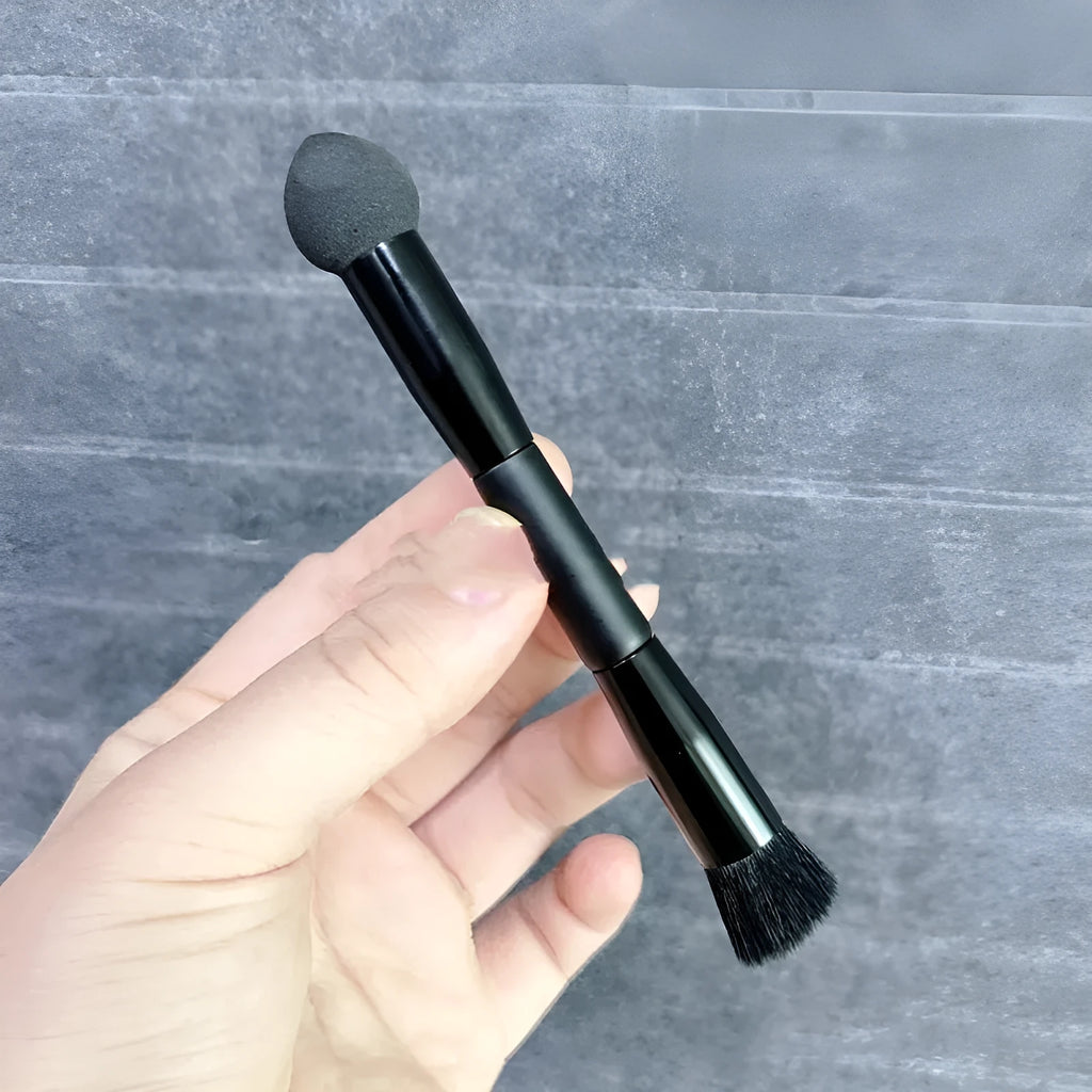 Black foam sponge tip concealer brush with a wooden handle for under-eye makeup application.