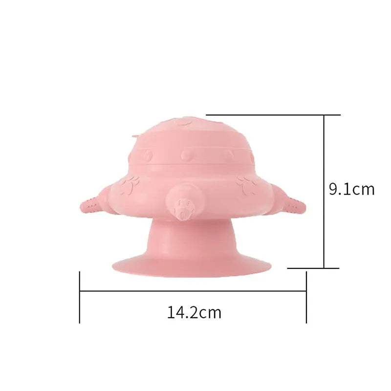Pink silicone pet nursing device with milk bowl and four pacifiers for puppies and kittens on a flat base.