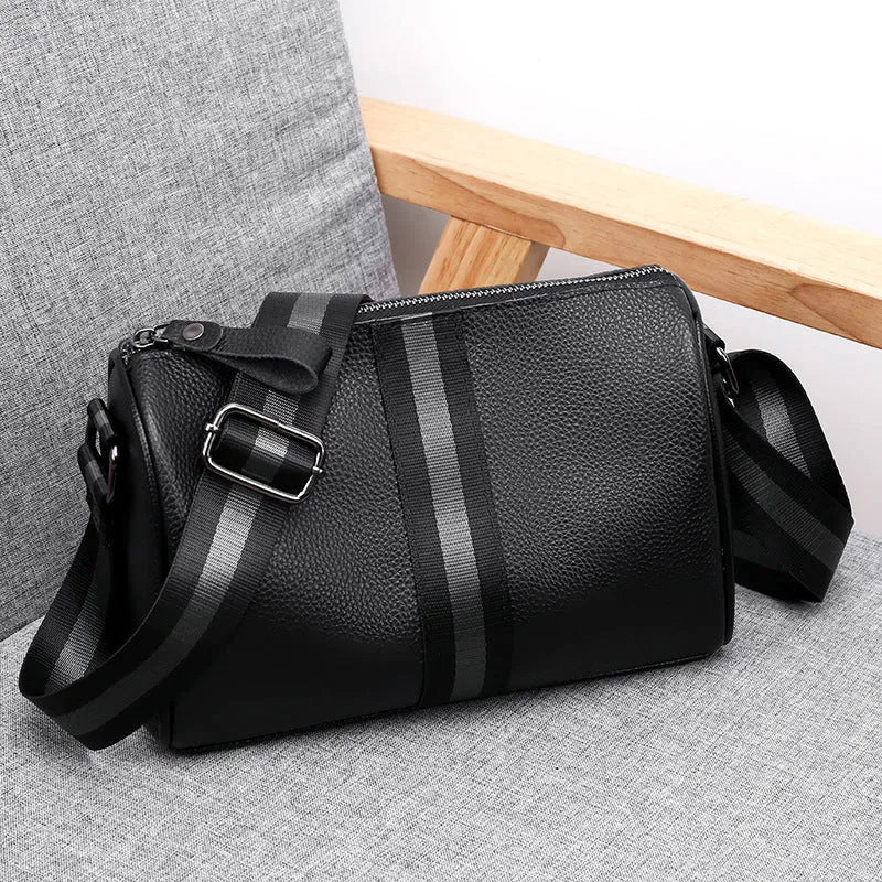 Black genuine leather one-shoulder crossbody bag showing front view and spacious interior.