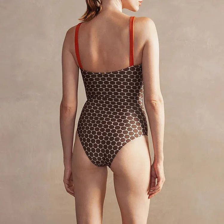 Women's blue dot print one-piece swimsuit with a matching wrap skirt laid flat.