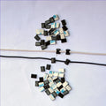 Black PA66 plastic cable management clip with steel wire ring for automotive electronics.