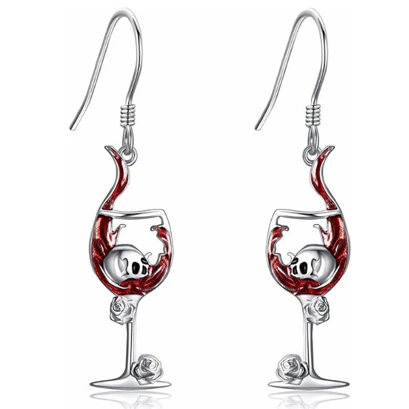 A pair of silver-toned zinc alloy earrings shaped like wine glasses adorned with skull details, on a plain background.