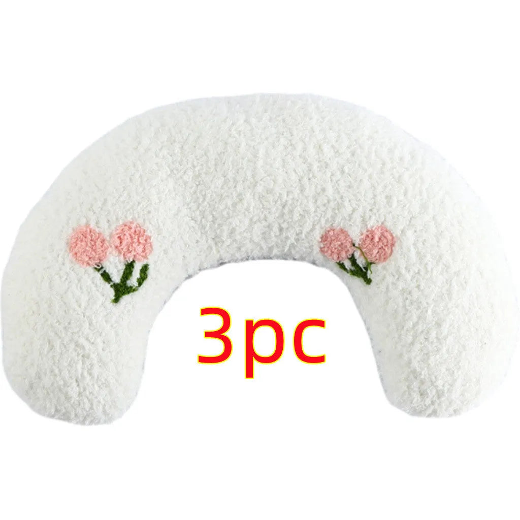 Small blue half-donut shaped pet pillow bed for cats or small dogs on a carpet.