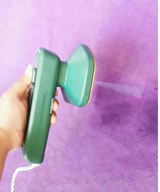 Dark green hand-held steam iron with ceramic panel showing dual temperature buttons and compact design