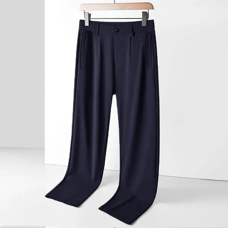 Man wearing black Ice Silk loose-fit straight-leg trousers with an elasticated waist for casual leisure wear.