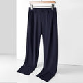 Man wearing black Ice Silk loose-fit straight-leg trousers with an elasticated waist for casual leisure wear.