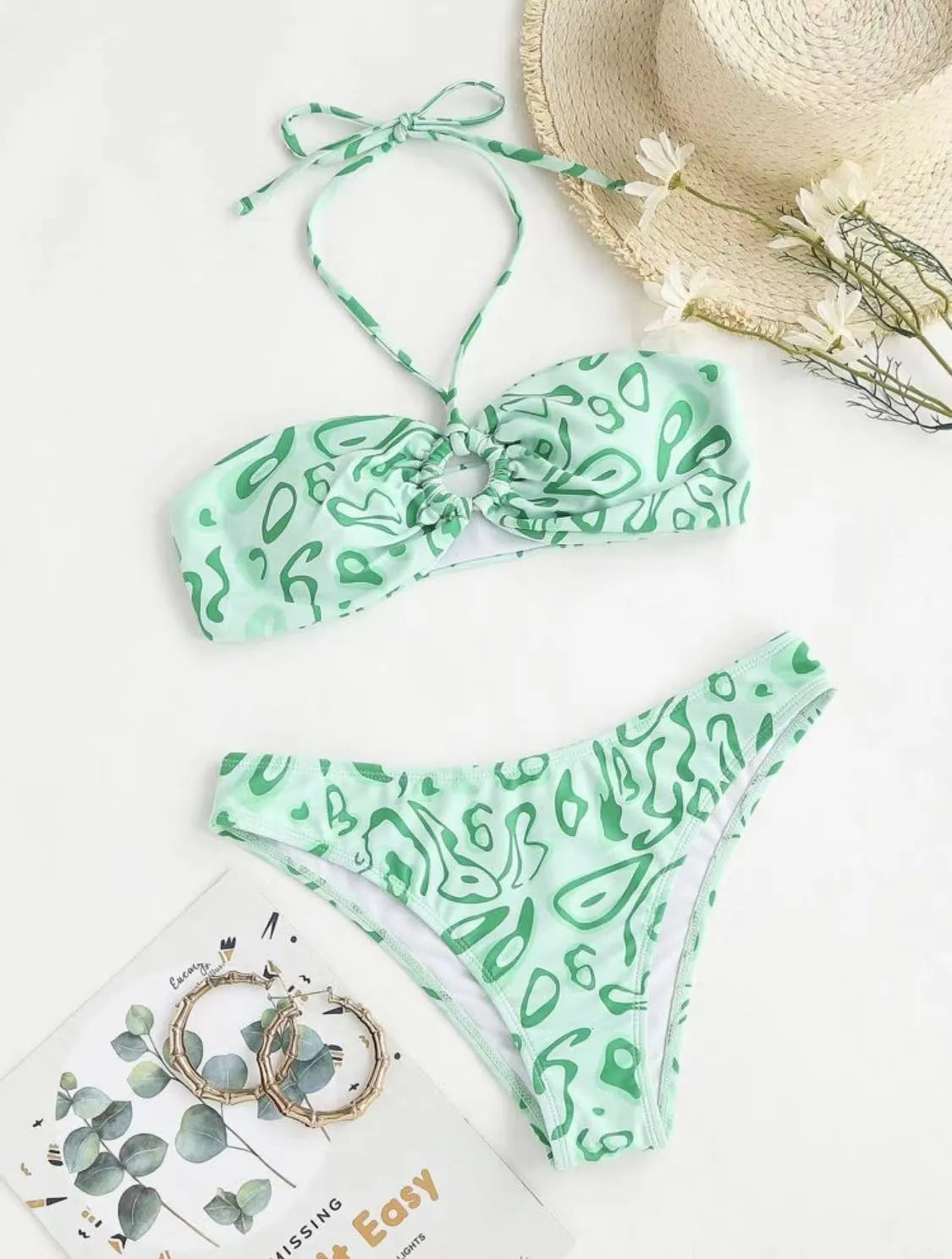 Green floral bandeau bikini swimsuit set with briefs on a neutral background.
