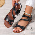 Women's flat sandals with black PU upper and Velcro strap fastening on a rubber sole.
