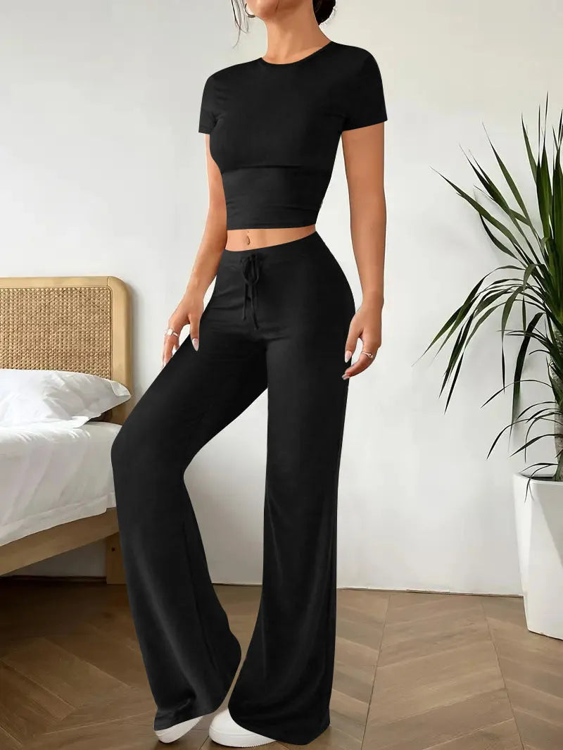 Women's black high waist trousers and regular sleeve t-shirt two-piece set laid flat.