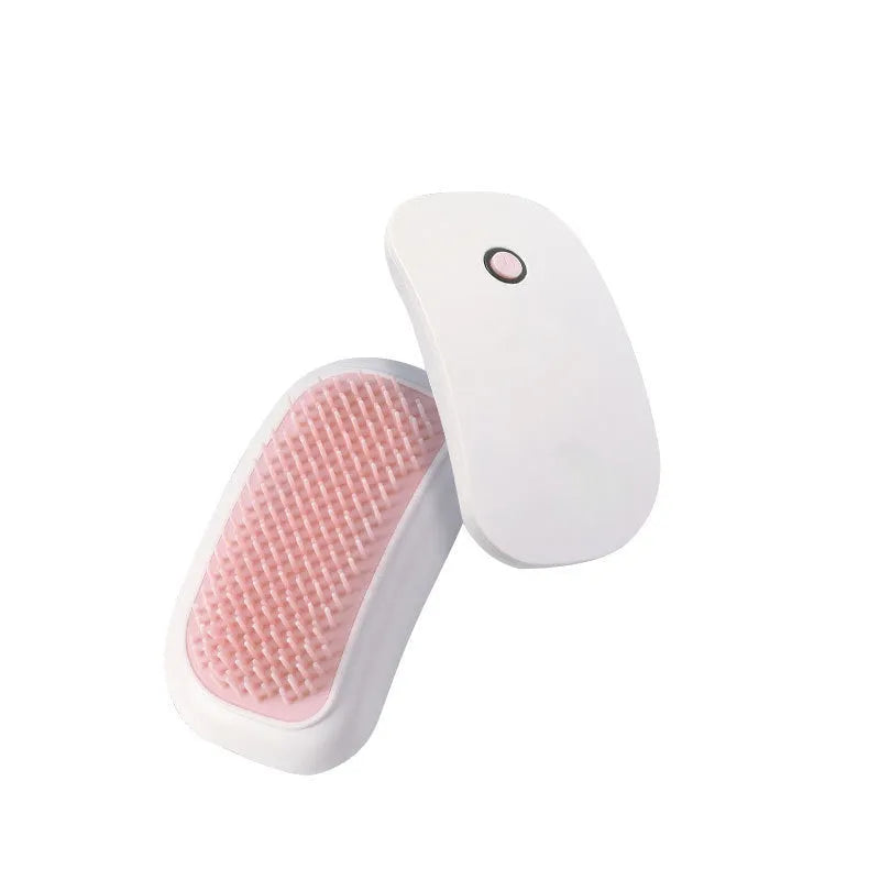 Pink handheld electric pet massage brush with soft teeth on a white background