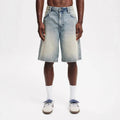 Man wearing loose light blue straight leg cotton denim jeans for casual summer streetwear.