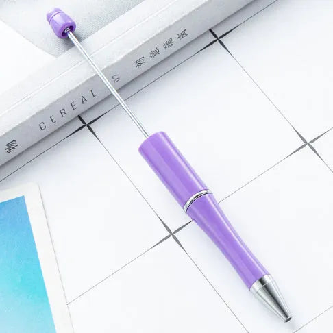 Ballpoint pen with colourful spinning plastic beads on barrel, shown in a gradient purple finish.