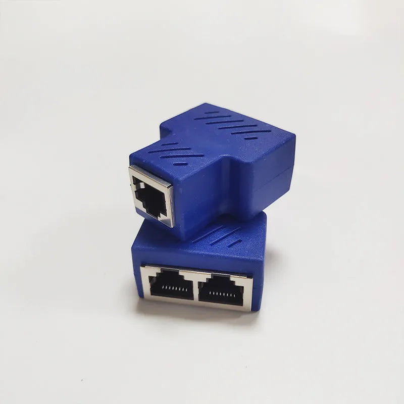 Two white RJ45 three-way network tee splitters on a table.