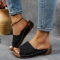 Women's wedge beach slippers with flower cutout design in black colour showing fish mouth toe shape