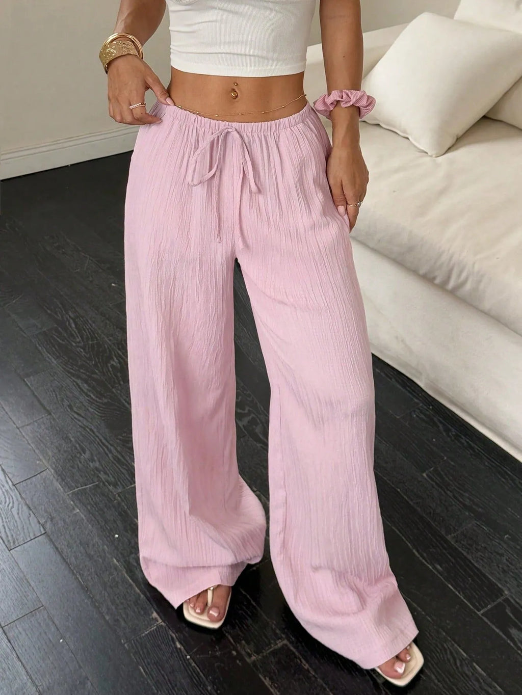 Women's black wide leg trousers with lace-up waist trimming detail on mannequin