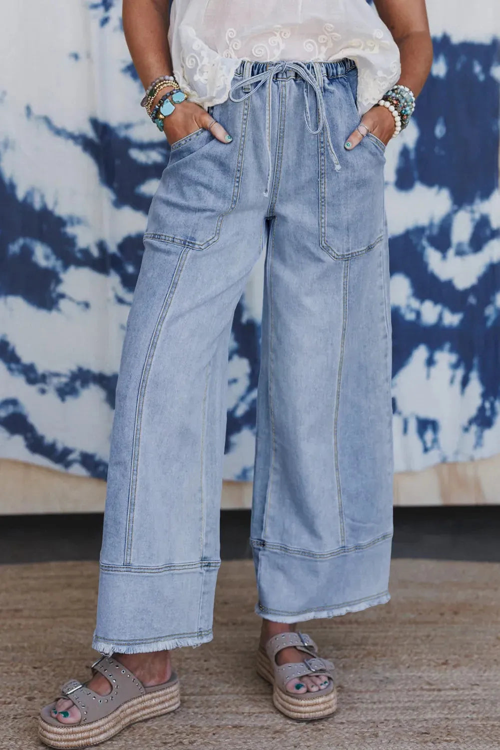 Beau Blue wide-leg women's jeans with a drawstring waistband and raw hem detail.
