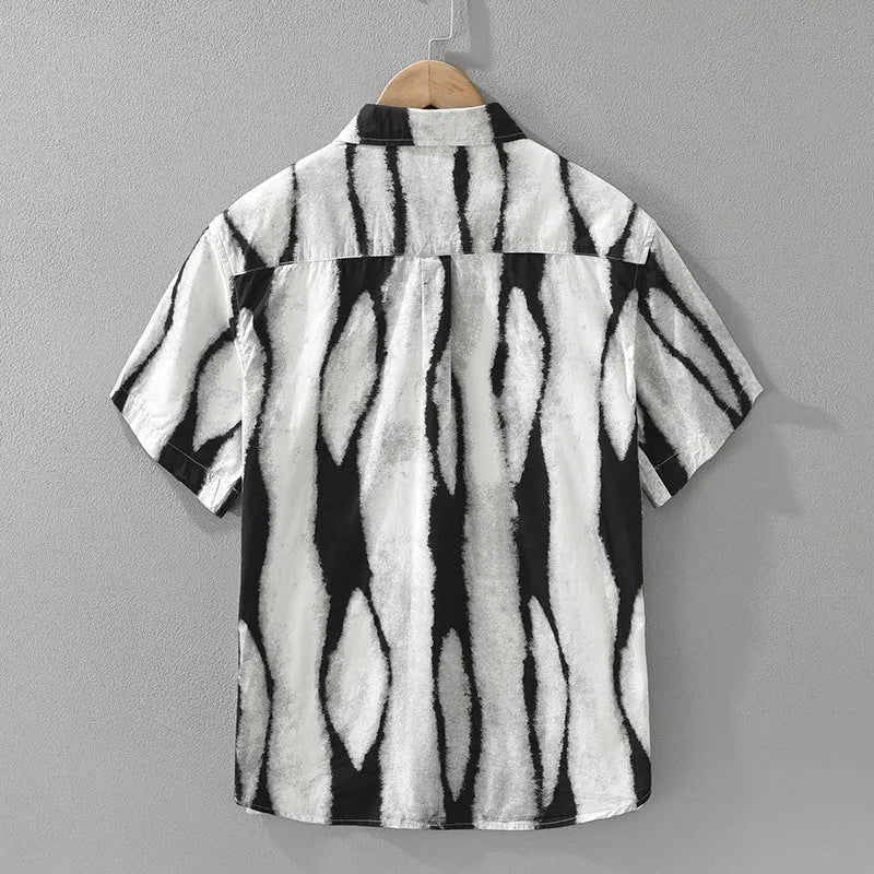 Man wearing a black and white retro striped loose-fit short sleeve cotton shirt.
