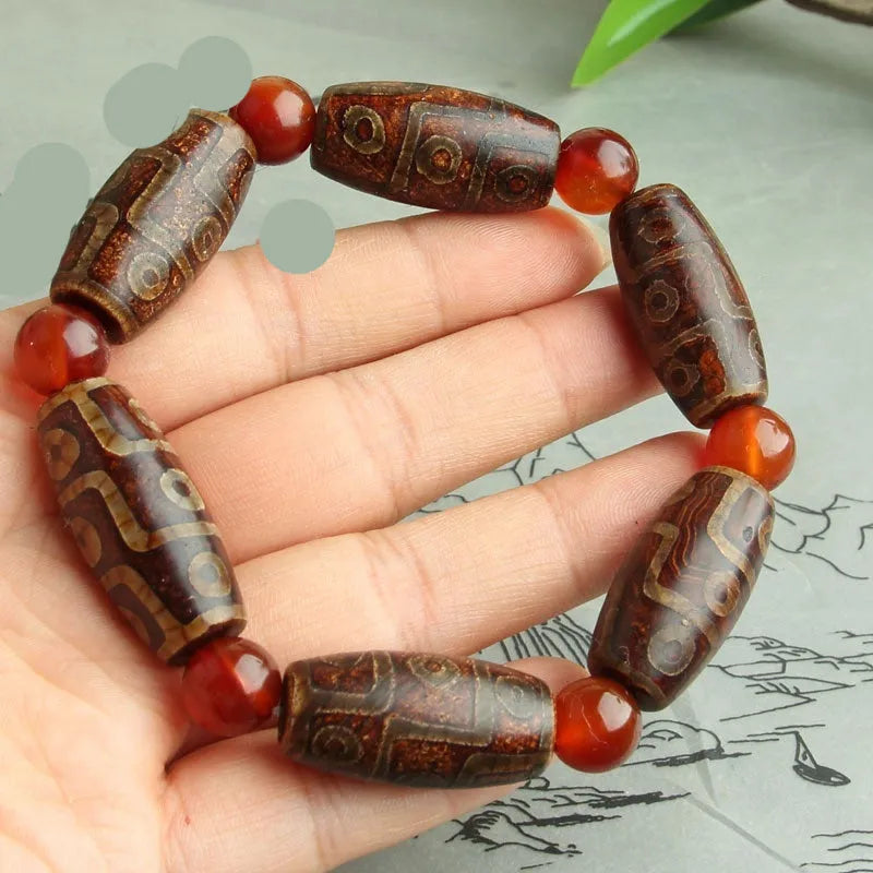 Distressed agate bracelet with traditional Tibetan dzi beads including three-eye and Nine Eyes designs.