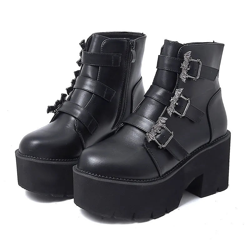 Black women's punk style short boots with bat buckle, thick heel, and side zipper.