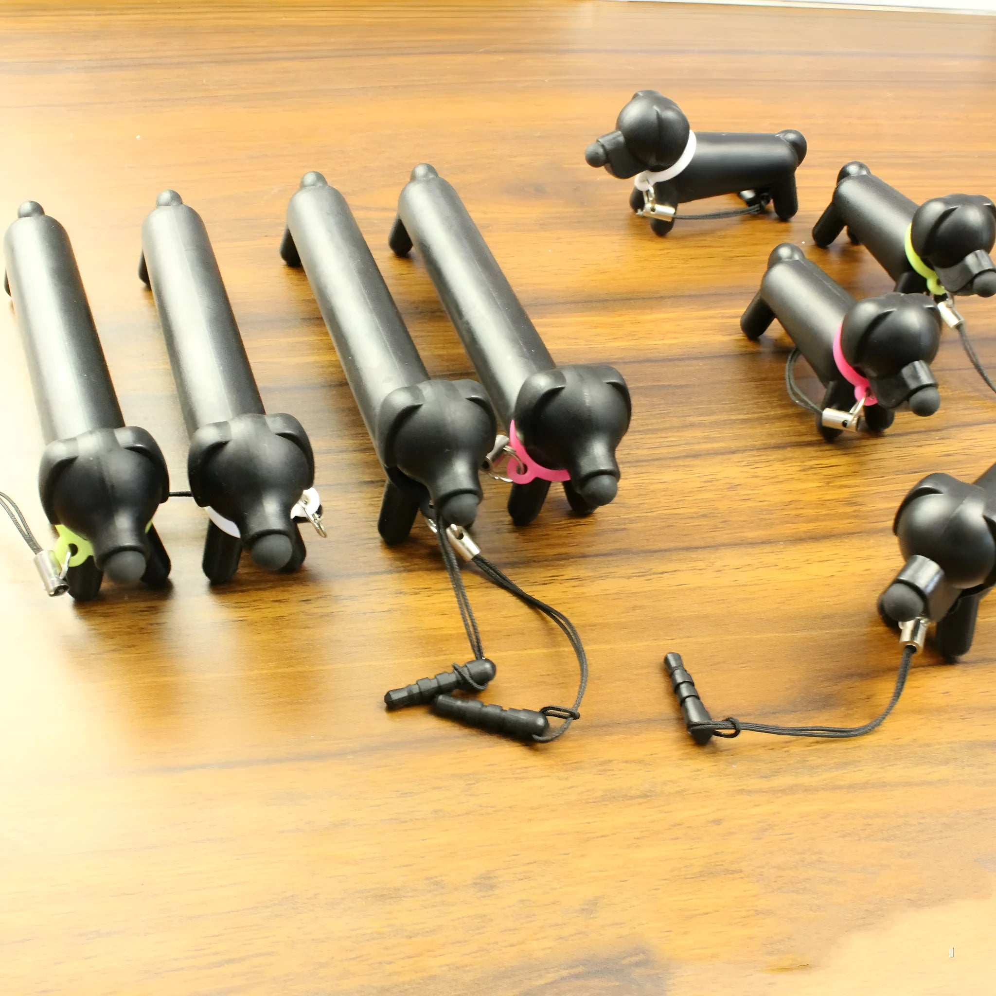 Black dog-shaped touch screen stylus showing dual-length design and phone holder function