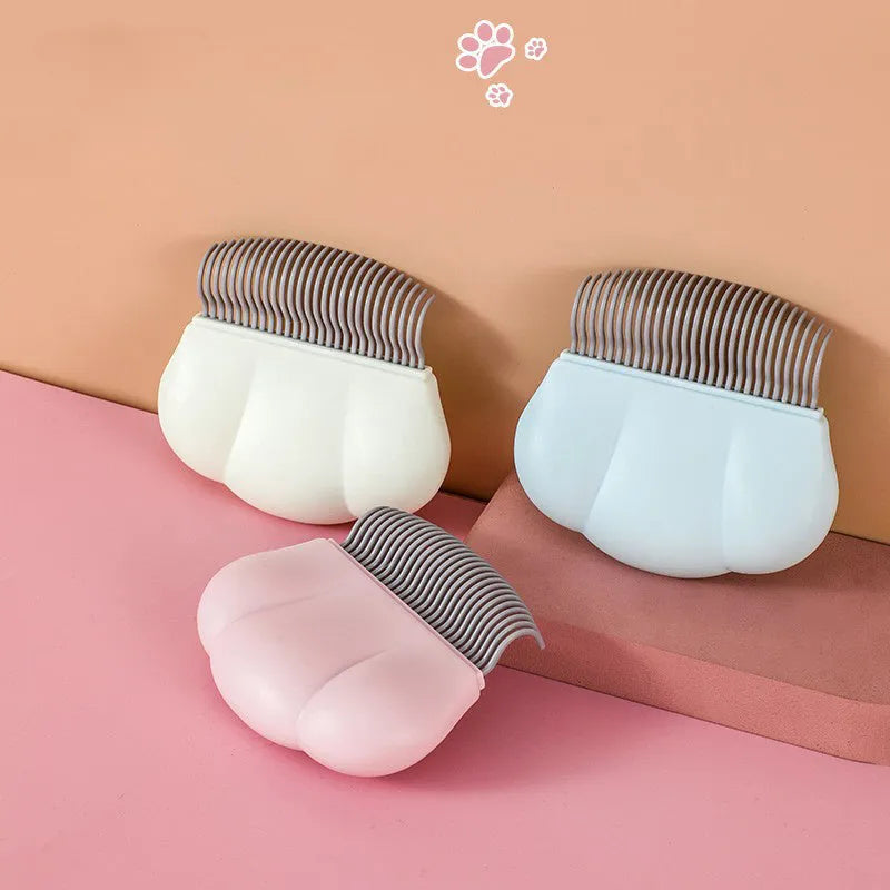 Paw Soft deshedding brush for cats and dogs in blue, pink, or white, shown with dimensions of 9cm by 9cm.