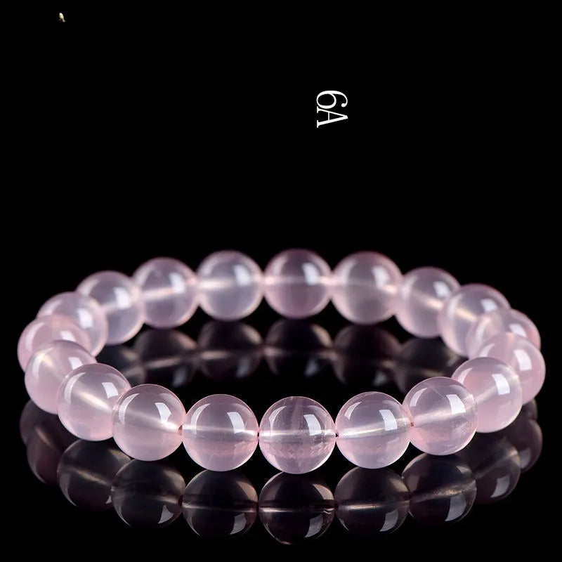 A pink crystal bead bracelet with polished round stones on a single strand.