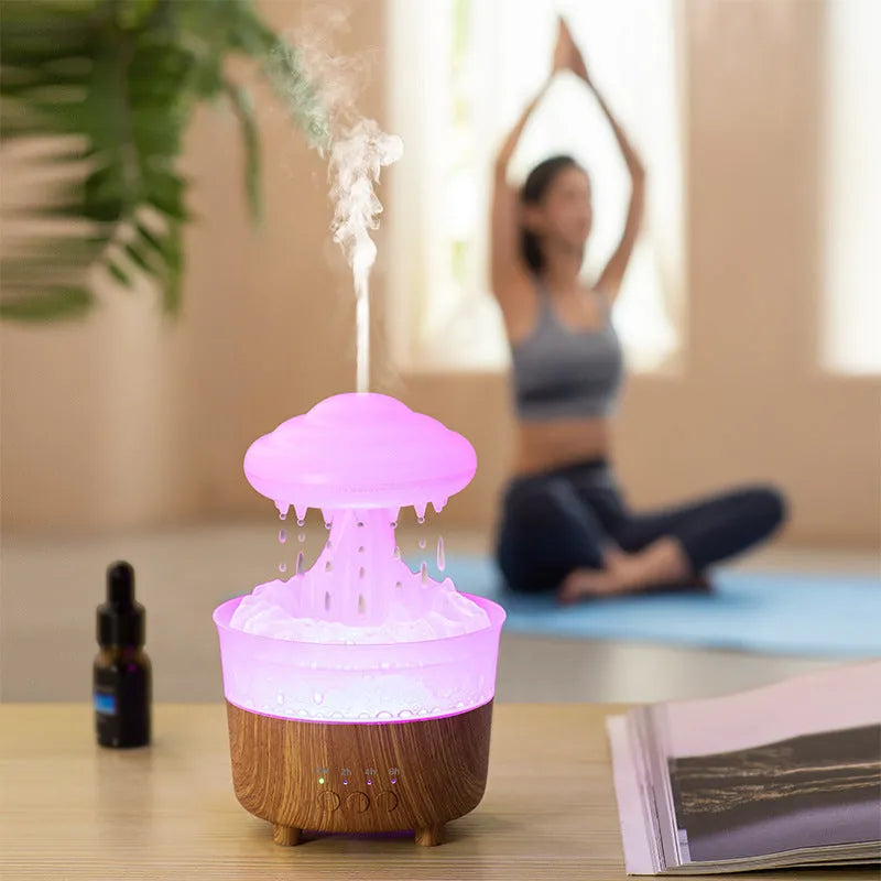 Rain cloud shaped humidifier with wood grain finish emitting mist and glowing with LED light