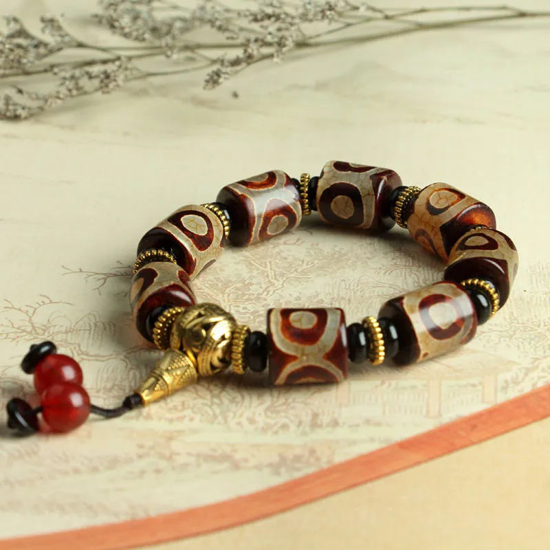 Distressed agate bracelet with traditional Tibetan dzi beads including three-eye and Nine Eyes designs.