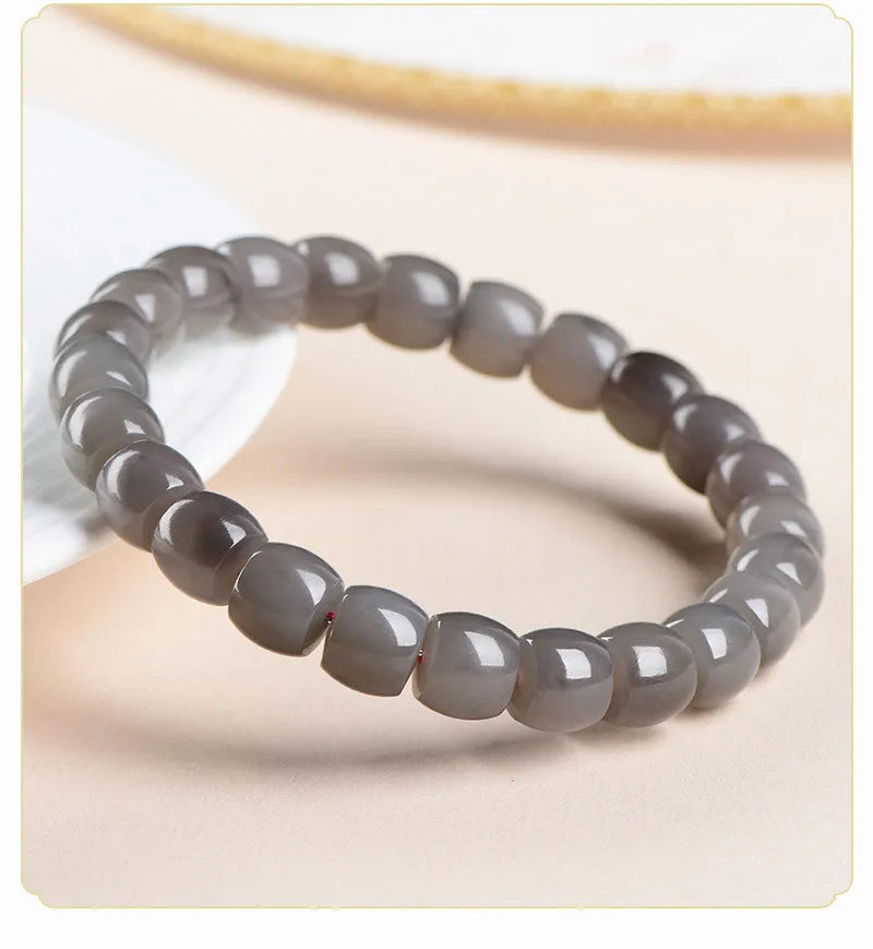 Natural smokey violet Hetian jade bracelet with straight cut beads on a wrist.