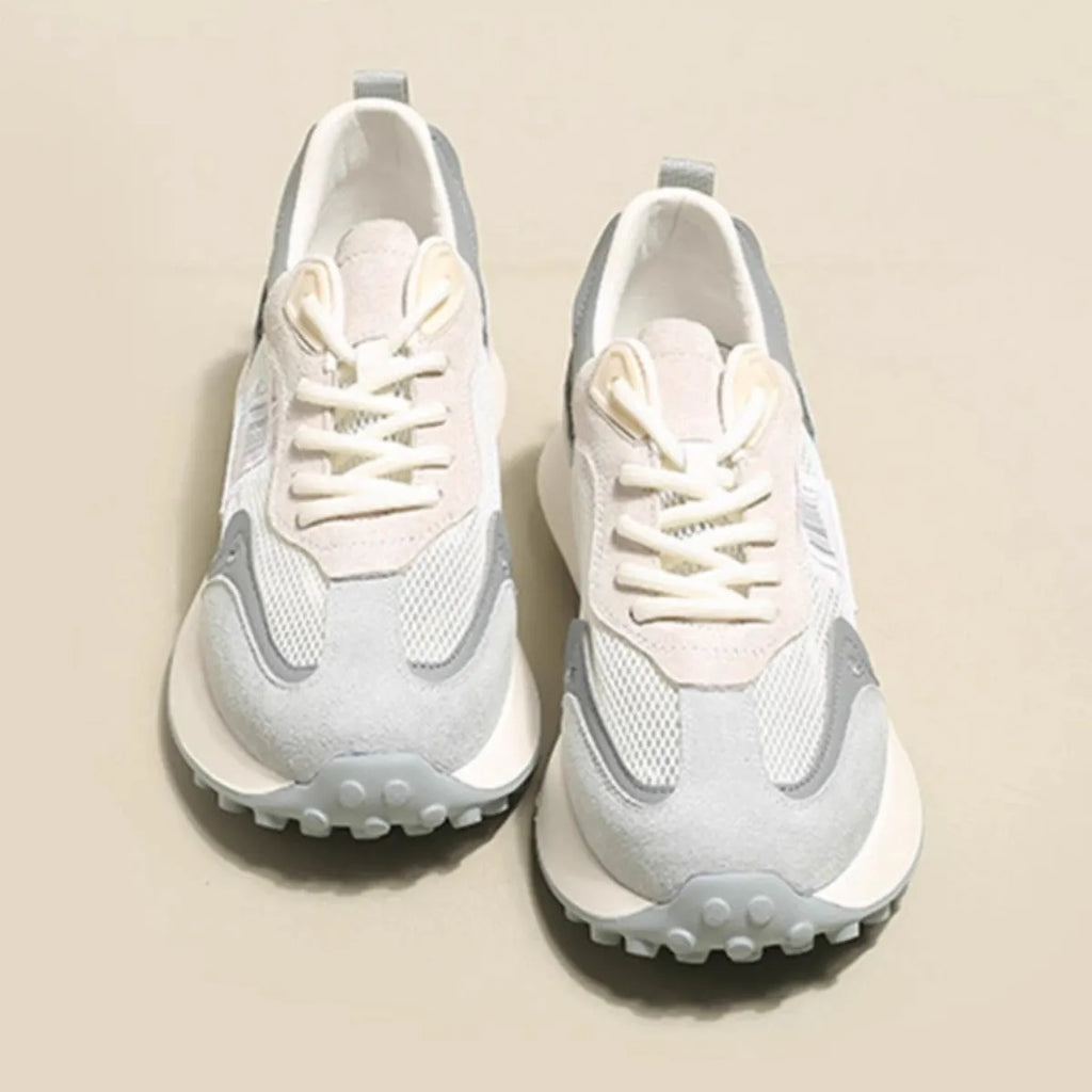 Grey and pink women's low-top retro sneaker with round toe and rubber sole on a white background.