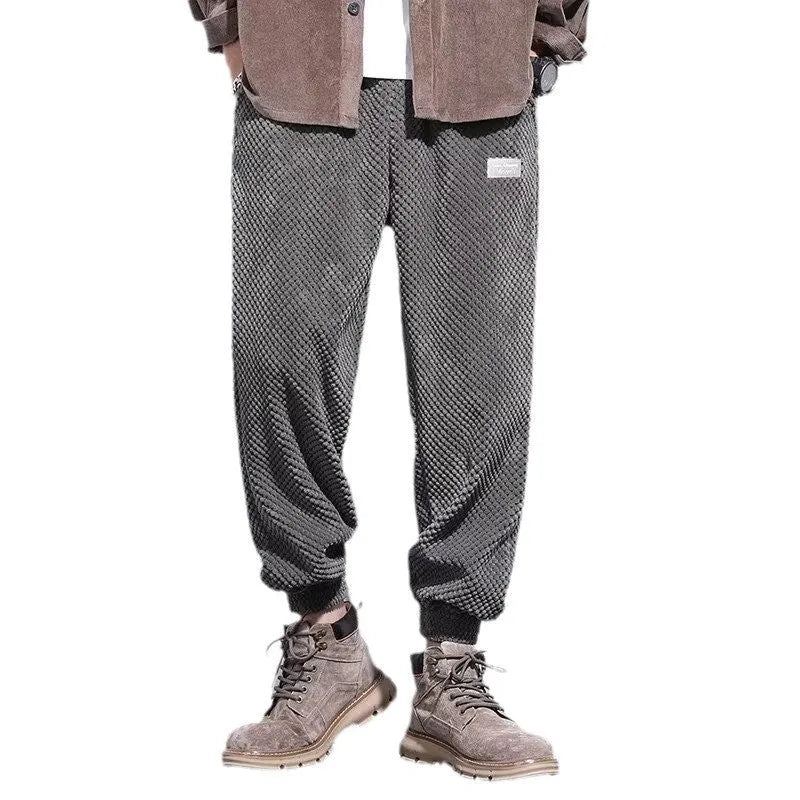 Men's grey ankle-tied straight-leg sweatpants laid flat, showing non-ironing polyester blend fabric.