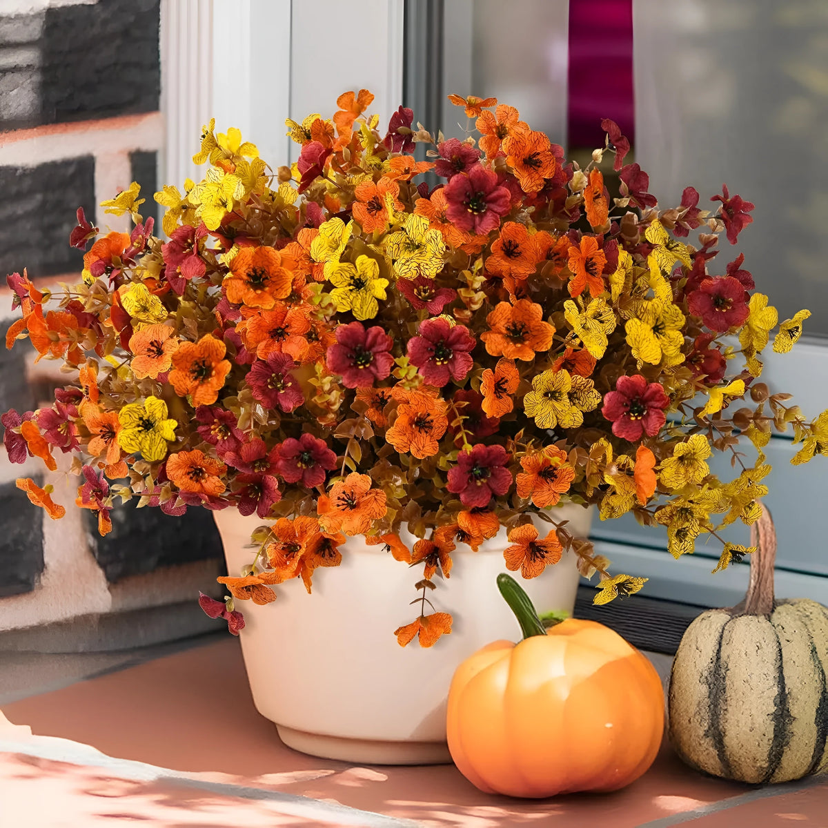 Artificial flower bouquet in autumn orange, red, and yellow colours for home and event decoration.