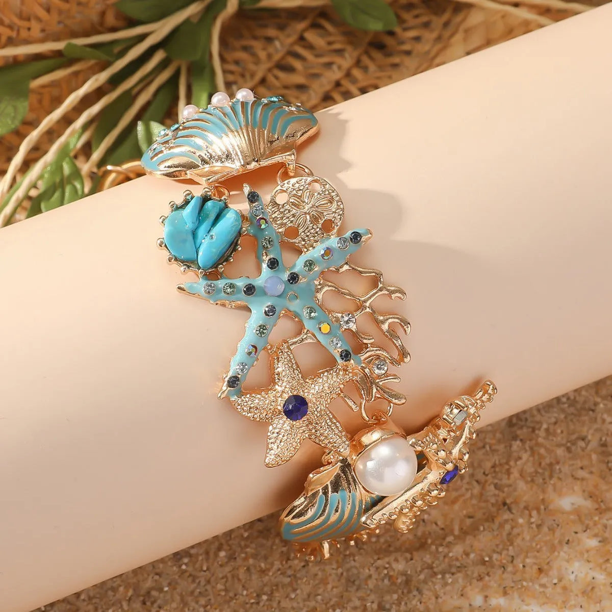 Women's alloy marine bracelet with boat anchor and starfish charms in turquoise, red, or blue coral colours.
