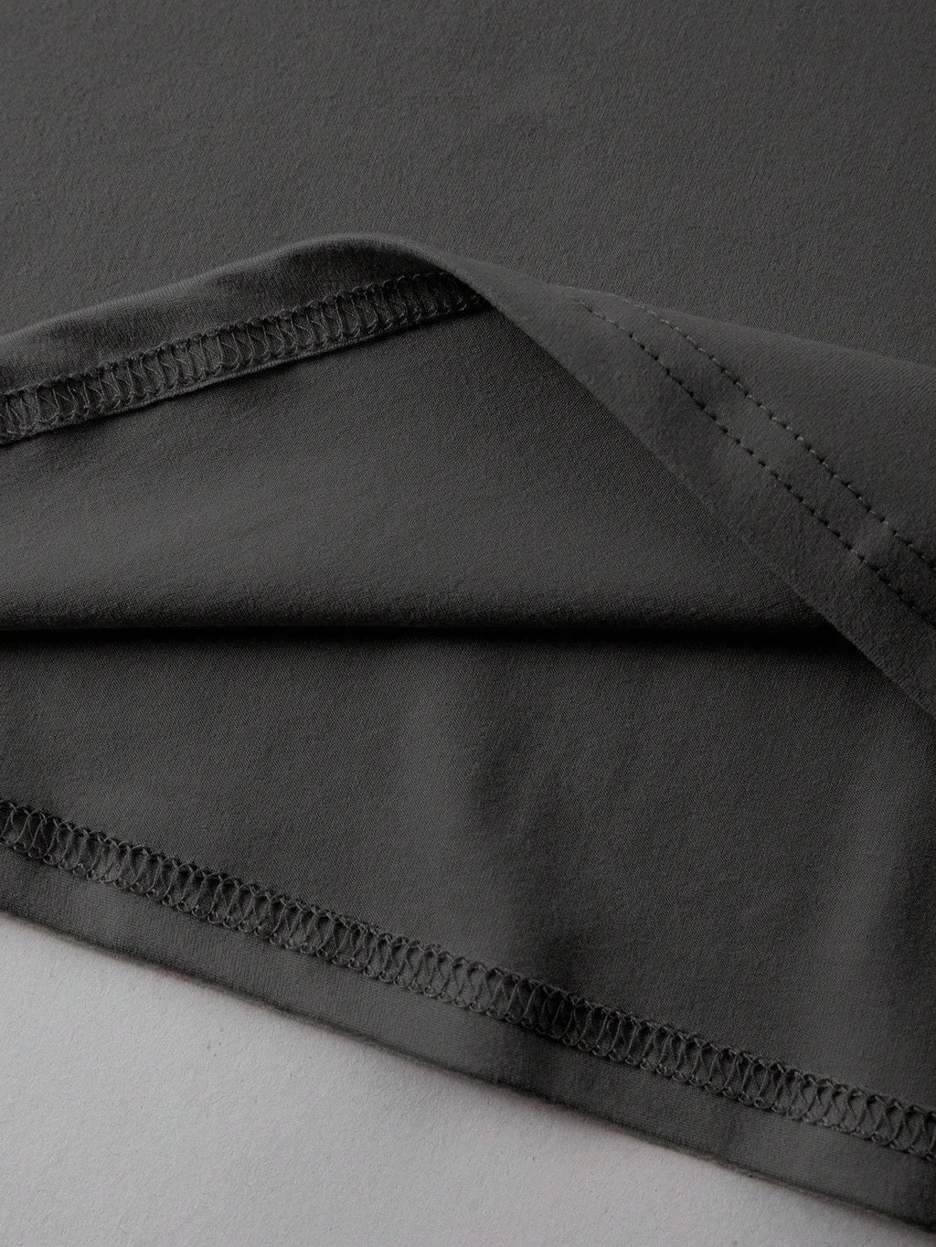 Loose fit cotton summer t-shirt in grey on a hanger, showing round neck and short sleeves.