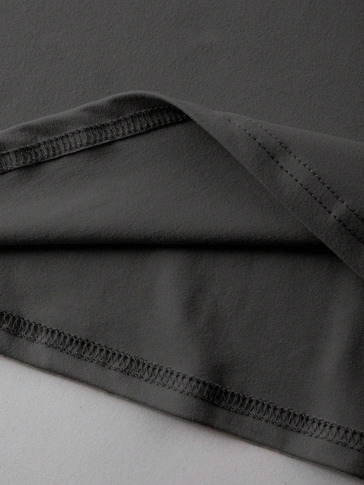 Loose fit cotton summer t-shirt in grey on a hanger, showing round neck and short sleeves.