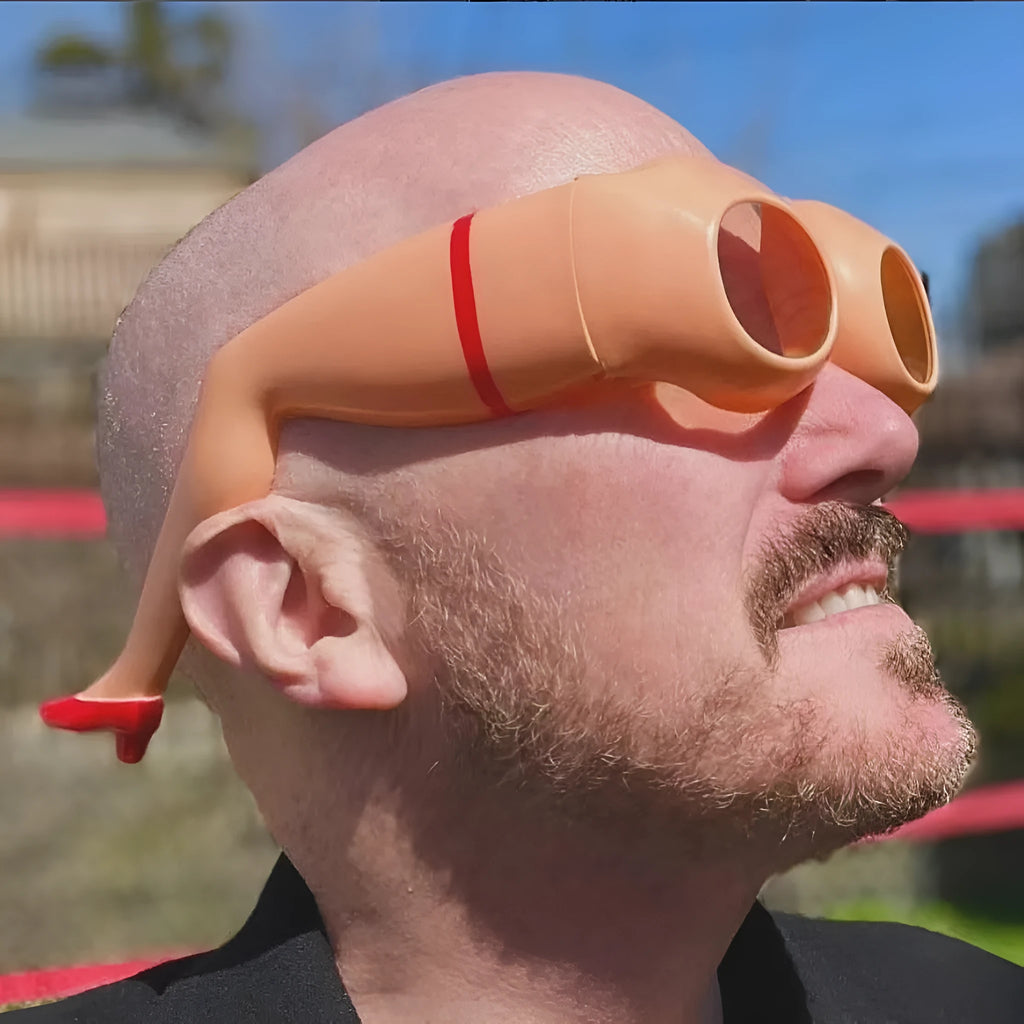 Orange plastic novelty sunglasses with a leg and hip design frame.