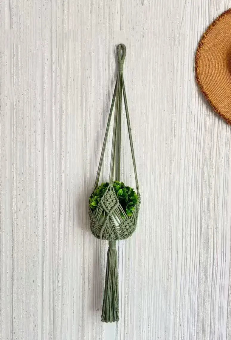 Hand-woven brown polyester cotton net pocket extension cord on a grey flower pot.