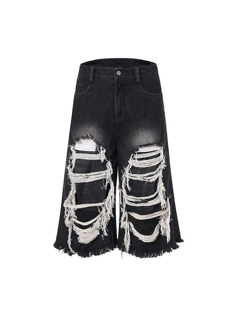 Women's black cropped wide leg jeans with distressed ripped patches and high waist