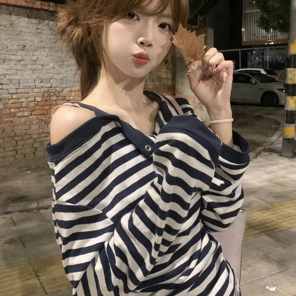 Dark blue oversized women's long-sleeved t-shirt with stripes and embroidery on a hanger.