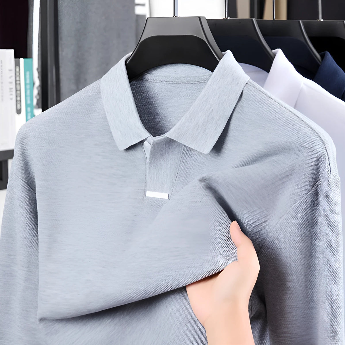 Man wearing a loose-fit grey cotton polo shirt with an asymmetric lapel, long sleeves, and a casual style.