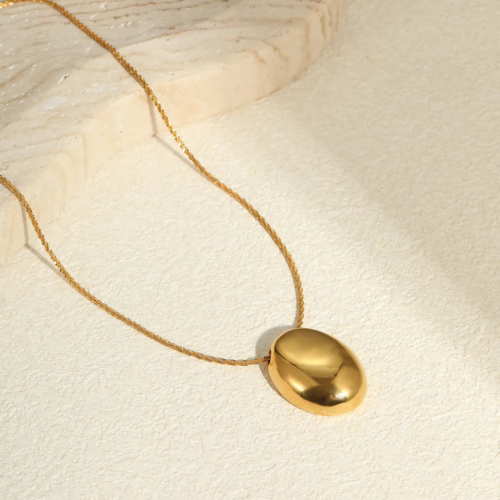 Gold geometric pendant necklace with adjustable chain on stainless steel background
