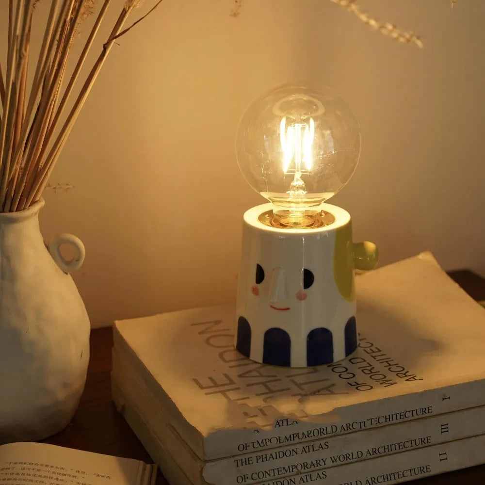 Handmade ceramic ball headlight bedside lamp on a table.