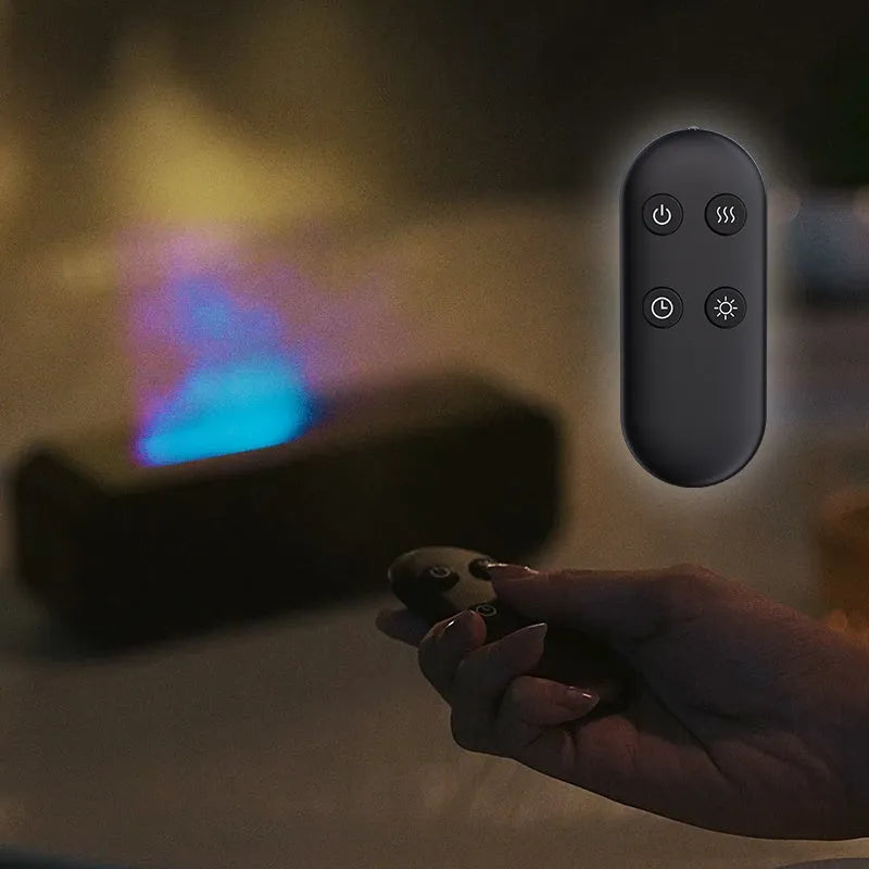 Black aroma diffuser with colour-changing flame light effect and remote control on a table.