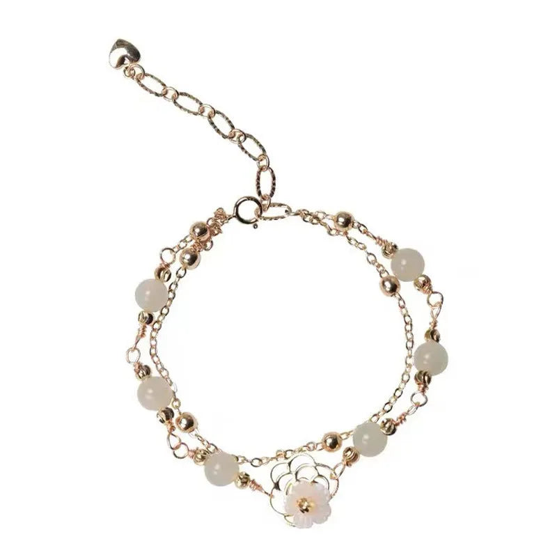 Yellow gold electroplated copper bracelet with shell flower butterfly charm containing Hetian jade elements