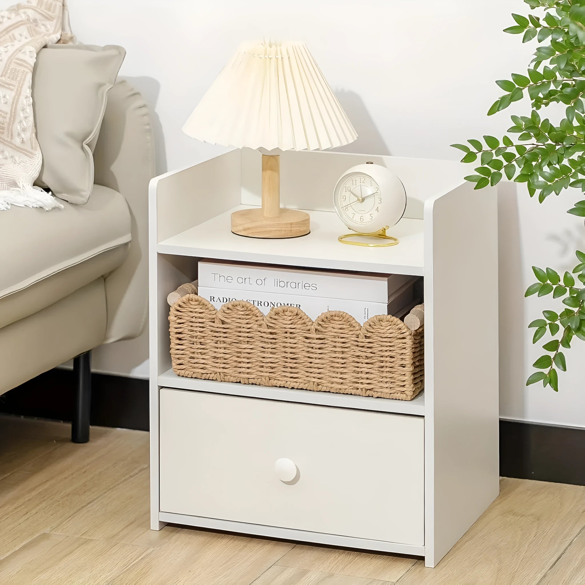 Woven paper storage basket in khaki colour on a wooden desk holding remote controls and pens.