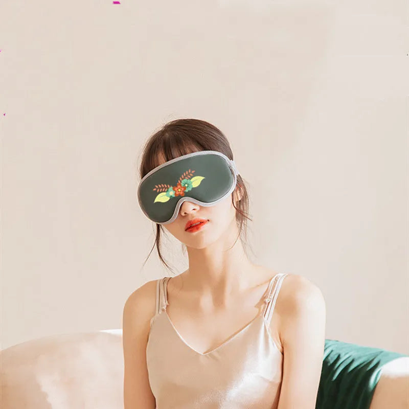 Green portable eye massage goggles showing USB connection and suede exterior